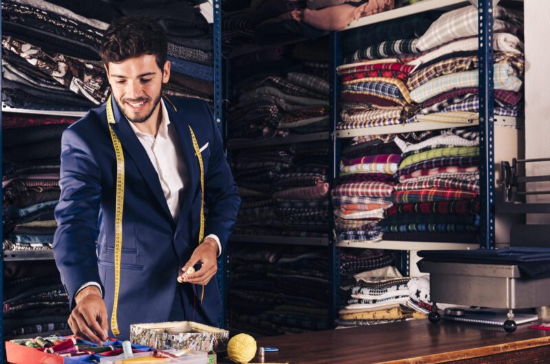 portrait-smiling-male-tailor-working-his-workshop-min